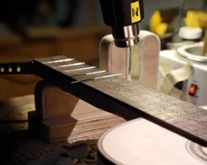 installing the frets on a guitar with a heatgun